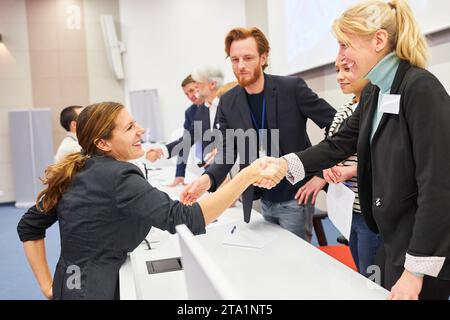 Souriant femme professionnelle poignée de main avec femme d'affaires sur scène pendant la conférence d'affaires dans l'auditorium Banque D'Images