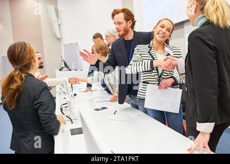 Heureuse femme d'affaires poignée de main avec collègue sur scène lors de l'événement d'affaires dans l'auditorium Banque D'Images