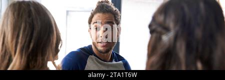 inspiré homme afro-américain parlant et partageant des idées avec des collègues féminines dans le bureau, bannière Banque D'Images