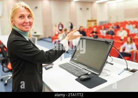 Portrait d'un orateur souriant sur le panel lors d'une conférence d'affaires faisant des gestes tout en parlant à l'auditoire Banque D'Images