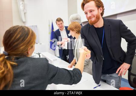 Homme d'affaires souriant poignée de main avec le public féminin sur scène pendant la conférence d'affaires dans l'événement Banque D'Images