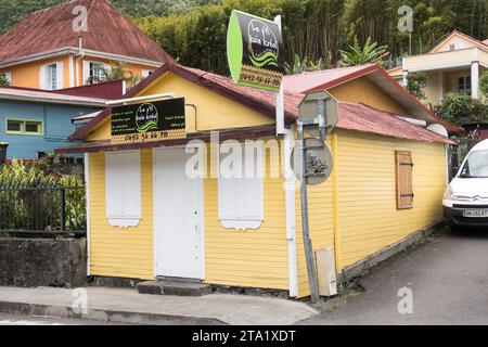 Le petit coin Kréol, boutique artisanale aux murs jaunes dans le village de Hell-Bourg, Ile de la Réunion, France. Portes vertes de façade orange. Banque D'Images