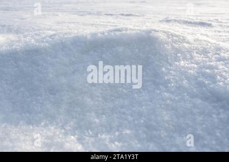 Texture de neige naturelle de la dérive de neige. Fond d'hiver avec sol enneigé. Motifs sculptés par le vent sur la surface de la neige. Espace de copie. Banque D'Images