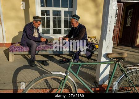 Istaravshan, Tadjikistan - 26 novembre 2023 : deux hommes jouent aux cartes à Istaravshan, Tadjikistan. Banque D'Images