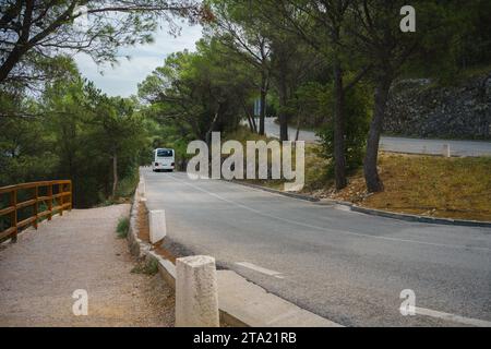 Bus touristique blanc conduisant sur une route de montagne sinueuse en Croatie Banque D'Images