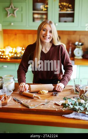 Les femmes étalent la pâte pour les biscuits de Noël Banque D'Images