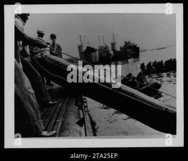 Divers navires, y compris des bateaux de pêche, des embarcations de débarquement, et l'USS Tripoli LPH-10, sont vus sur cette image représentant les activités militaires américaines pendant la guerre du Vietnam. Ces bateaux ont joué un rôle crucial dans les opérations maritimes et le transport du personnel et des fournitures pendant le conflit. Banque D'Images