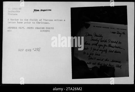 Un Marine stationné au Vietnam écrit une lettre chez lui avant Noël, réfléchissant à son service alors qu'il était loin de sa famille. La photographie capture la vie quotidienne et la correspondance du personnel militaire américain pendant la guerre du Vietnam. Banque D'Images