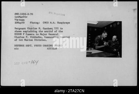 Le sergent Charles H. Gardner, III présente les caractéristiques de la caméra NIKON F au major général C.F. Widdecke, commandant général de la 1e division des Marines. L'événement a eu lieu le 20 mai 1970, pendant la guerre du Vietnam. La photographie a été prise par CW03 A.A. Humphreys, photographe de combat pour Time/Life. Banque D'Images