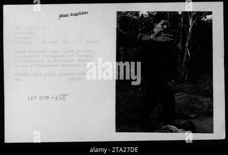 Le caporal James Lynch détient un individu vietnamien présumé pendant la guerre du Vietnam en mai 1970. Le but de la détention est de procéder à un nouvel interrogatoire afin de déterminer si l ' intéressé est communiste vietnamien ou non. Cette photographie fait partie de la collection du ministère de la Défense, avec le numéro d'identification 4373692. Banque D'Images