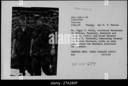 Le secrétaire adjoint à la Défense, M. Roger P. Kelly, et le commandant général de la 1e division des Marines, le major-général Charles F. Widdecke, sont vus marchant et prenant part à des conversations au cantonnement de l'artillerie du Nord pendant la guerre du Vietnam. Cette image a été prise le 15 mai 1970 par le sergent R. W. Malson. Banque D'Images