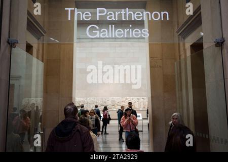 L'entrée des galeries du Parthénon au British Museum de Londres où les visiteurs admirent les métopes du Parthénon grec ancien, également connues sous le nom de marbres du Parthénon (Elgin), le 28 novembre 2023, à Londres, en Angleterre. Quatre-vingt-douze métopes étaient des dalles de marbre rectangulaires placées sur les colonnes du temple du Parthénon d'Athènes représentant des scènes de la mythologie grecque. Banque D'Images