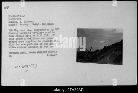 Des Marines du 7e bataillon du génie, 3e division des Marines, sont photographiés travaillant sur des activités de construction sur un site de missiles Hawk situé sur la colline 327 à Danang, au Sud-Vietnam. La photographie, prise le 8 mars 1965 par GySgt. Hallahan, montre un bulldozer et une pelle mécanique fournissant simultanément de la terre de remblai pour une zone et élargissant une autre partie de la route menant au site. Cette image est une photo du ministère de la Défense du corps des Marines. Banque D'Images