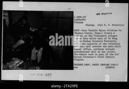 Myron Alluklan Jr., dentiste du corps des Marines, fournit des soins dentaires dans un centre de réfugiés près de Da Nang dans le cadre du programme des affaires civiles de la 3e Division des Marines, traitant des patients volontaires dans une clinique de fortune. Banque D'Images