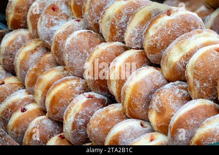 Beignets de confiture fraîchement préparés empilés sur un étal de nourriture dans une salle de restauration dans Spitalfields Market, Londres, Royaume-Uni Banque D'Images