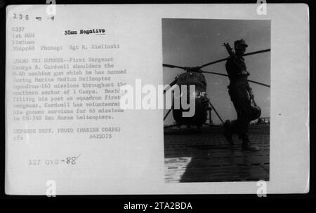 Le premier sergent George B. Cardwell du Marine Medium Helicopter Squadron-163 est vu ici endossant une mitrailleuse M-60 qu'il a pilotée lors de missions dans le secteur nord du I corps au Vietnam. En plus de ses fonctions de premier sergent d'escadron, Cardwell s'est porté volontaire comme mitrailleur pour 68 missions dans des hélicoptères UH-34D Sea Horse. Banque D'Images