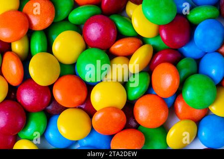 Une pile de boutons de chocolat enrobés de bonbons de couleur arc-en-ciel isolés Banque D'Images