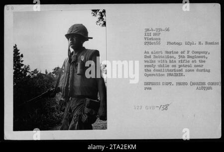 Un Marine de la compagnie F, 2e bataillon, 5e régiment, garde son fusil prêt alors qu'il patrouille près de la zone démilitarisée pendant l'opération PRAIRIE. La photographie, prise le 27 octobre 1966, capture les combats intenses vécus par les troupes américaines pendant la guerre du Vietnam. Banque D'Images