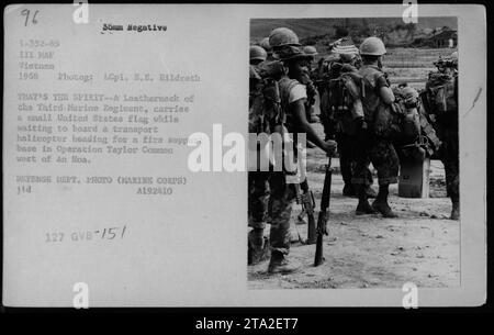 Le Marine du 3e régiment de Marines porte un petit drapeau américain en attendant d'être transporté vers une base d'appui-feu dans le cadre de l'opération Taylor Common. La photo a été prise en 1968 par le Lcpl. E.E. Hildreth pendant la guerre du Vietnam. Banque D'Images