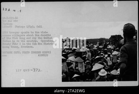 Un soldat AMÉRICAIN partage des informations sur les tactiques trompeuses du Viet Cong avec les villageois vietnamiens lors de l’opération County Fair I dans le district de Cam Hoa de la province de Cung Treng, au Vietnam. Date : 12 décembre 1966. Photo prise par L/Cpl. Appelez. Photo du ministère de la Défense (corps des Marines) A188059. (Légende de l'image : un soldat américain s'engage avec des villageois vietnamiens pendant la guerre du Vietnam.) Banque D'Images