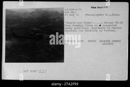 Un Marine UH-1E Huey Gunship tire sur des positions suspectes ennemies, au sud-ouest de Marble Mountain Air Facility au Vietnam. La photographie, prise par le GySgt H. Mahan le 17 mai 1971, illustre l'intensité de la mission « Search and Clear ». Les hélicoptères vus dans l'image sont des UH-1, couramment utilisés par l'armée américaine pendant la guerre du Vietnam. Banque D'Images