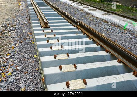 Pose de nouveaux rails de tramway sur de nouvelles traverses en béton avec des patins qui réduisent les vibrations et les émissions sonores Banque D'Images