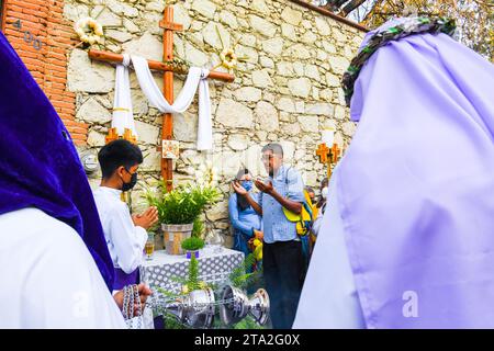 Les pratiquants prient devant les autels du quartier pendant la procession silencieuse du Vendredi Saint, ville d'Oaxaca, Mexique Banque D'Images