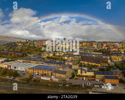 Vue aérienne de la ville de Puigcerdà entourée d'un arc-en-ciel (Cerdanya, Catalogne, Espagne, Pyrénées) ESP : Vista aérea de Puigcerdà y un arco iris Banque D'Images