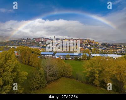 Vue aérienne de la ville de Puigcerdà entourée d'un arc-en-ciel (Cerdanya, Catalogne, Espagne, Pyrénées) ESP : Vista aérea de Puigcerdà y un arco iris Banque D'Images