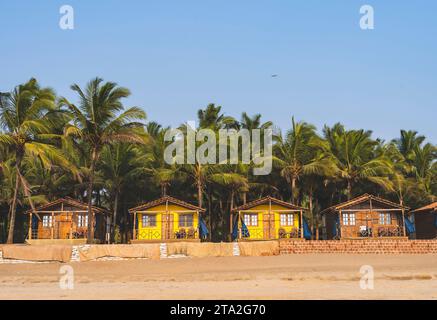Cabanes colorées sur la plage Agonda avec des palmiers à Goa, en Inde Banque D'Images