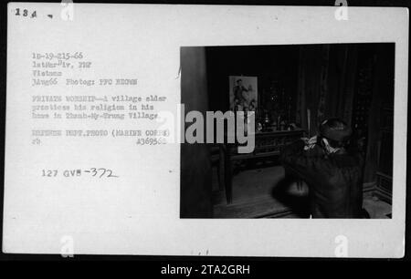 'Un aîné de village vietnamien s'engage dans un culte privé dans sa maison dans le village de Thanh-NY-Trung, Vietnam le 3 août 1966. Cette photographie, prise par le FFC Brown du ministère de la Défense, représente une représentation intime des pratiques religieuses civiles pendant la guerre du Vietnam. » Banque D'Images