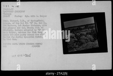 Les soldats AMÉRICAINS Richard L.H. et J.L. Mundy, stationnés au Vietnam pendant l’opération DeSoto, sont engagés dans l’entraînement et la reconnaissance des tireurs d’élite. Photographiés le 3 février 1967, ils observent attentivement le paddy de l'autre côté de la rivière à des Pho, à la recherche d'un éventuel mouvement Viet Cong. Crédit image : Sgt Adin L. Cooper, US Marines. Banque D'Images