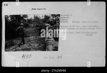 Marines de la compagnie 'B', premier bataillon, troisième régiment en patrouille à travers la ville pendant le combat au Vietnam le 24 février 1968. La photographie, prise par un photographe du corps des Marines, capture les activités militaires de la 3e Division des Marines pendant la guerre du Vietnam. Banque D'Images