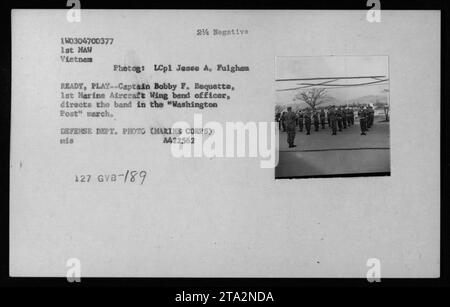 Légende : « le capitaine Bobby F. Bequette, officier de la 1e Marine Aircraft Wing, dirige le Drum and Bugle corps du 1e MAW lors d'une représentation de la marche du Washington Post pendant la guerre du Vietnam. Photographié par le Lcpl Jesse A. Fulghan.' Banque D'Images