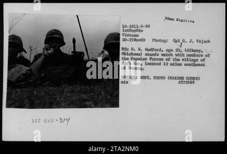 Le PFC D. S. Wadford, un soldat de 20 ans d'Albany, Oklahoma, est photographié debout avec des membres des Forces populaires du village de Bich bac dans une photographie prise par le photographe du corps des Marines, le Cpl G. J. Vojack, le 20 novembre 1969. Cette image est des activités de l'ARVN (Armée de la République du Vietnam) pendant la guerre du Vietnam. Banque D'Images