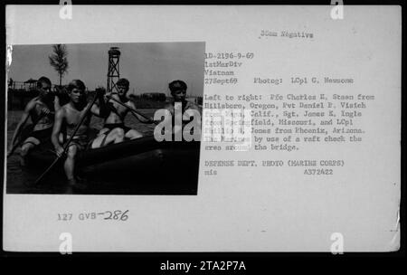 Des Marines de la 1e Division des Marines, au Vietnam, patrouillent autour d'un pont à l'aide d'un radeau le 27 septembre 1969. La photographie capture les Marines, y compris Pie Charles E. Steen, le soldat Daniel P. Visich, le sergent James E. Ingle et le lcpl Phillip B. Jones, vérifiant les environs. Cette image fait partie des photographies du ministère de la Défense des activités militaires américaines pendant la guerre du Vietnam. Banque D'Images