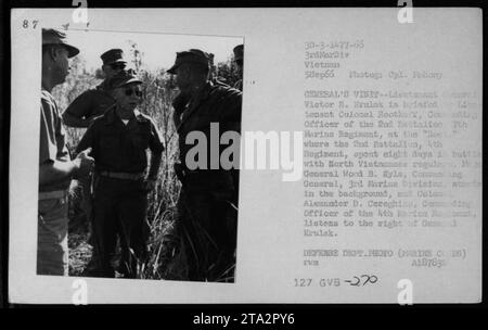 Le lieutenant-colonel Victor H. Krulak est informé par le lieutenant-colonel Roothoff, commandant du 2e bataillon, 7e régiment de Marines, lors d'une visite au Roc au Vietnam, où le 2e bataillon, 4e régiment s'était récemment engagé dans une bataille contre les forces nord-vietnamiennes. Le général Wood B. Kyle, commandant de la 3e Division des Marines, peut être vu en arrière-plan, tandis que le colonel Alexander D. Cereghino écoute. Cette photographie a été prise le 5 septembre 1966, lors d'une visite de fonctionnaires, dont le président Lyndon Johnson et le colonel P.X. Kelley. Banque D'Images