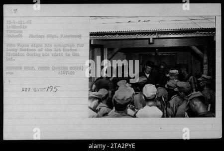 John Wayne signe un autographe pour les Marines de la 1e Division des Marines lors de sa visite à Chu Lai au Vietnam le 20 juin 1966. La photographie a été prise par Signalman Fleetwood et est une photo officielle du ministère de la Défense. Banque D'Images