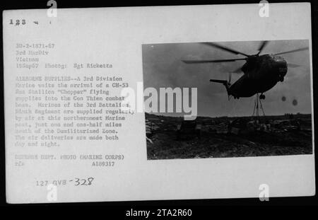 Un membre de la 3e Division Marine attend l'arrivée d'un hélicoptère CH-53 Sea Stallion livrant du ravitaillement à la base de combat de con Thien. La base, située juste au sud de la zone démilitarisée, reçoit régulièrement des livraisons aériennes de marchandises, de jour comme de nuit, pour soutenir les Marines stationnés là-bas. Banque D'Images