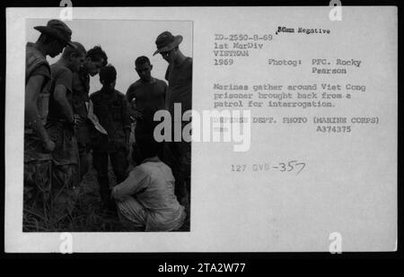 Des Marines de la 1e Division des Marines au Vietnam, 1969, sont vus autour d'un prisonnier Viet Cong qui a été appréhendé lors d'une patrouille. Les Marines encerclent le suspect, se préparant à l'emmener pour interrogatoire. Cette image capture les activités militaires et les procédures suivies pour identifier et interroger les membres du Viet Cong capturés pendant la guerre du Vietnam. Banque D'Images