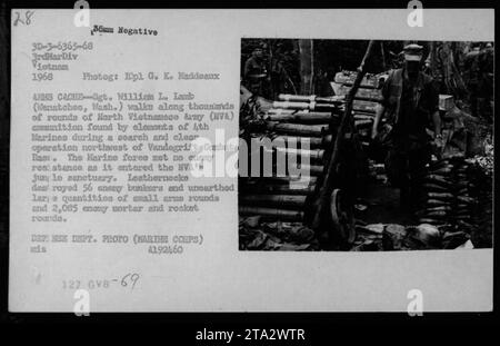 Le Sgt William L. Lamb est vu marchant à côté d'une grande réserve de munitions de l'armée nord-vietnamienne qui a été saisie lors d'une opération de recherche et de nettoyage près de la base de combat de Vandegrift. L'opération, menée par des éléments du 4th Marines, a conduit à la destruction de 56 bunkers ennemis et à la découverte de milliers de munitions d'armes légères, ainsi que de plus de 2 000 obus de mortier et de roquettes. Banque D'Images