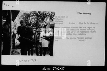 Le caporal Hinsor et l'unité du Groupe d'action combiné-4 au Vietnam, 28 août 1968. Sur cette photo, ils sont vus en train de vérifier les cartes d'identité des villageois dans une zone où l'activité Viet Cong était présente. Cette image est une documentation du rôle joué par l'Armée de la République du Vietnam (ARVN) pendant la guerre du Vietnam. Banque D'Images
