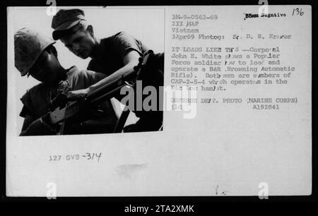 Un membre de l'armée de la République du Vietnam (ARVN), le corps John E. White, démontre à un soldat de la Force populaire comment charger et utiliser un fusil automatique Browning (BAR). La photographie a été prise le 3 avril 1969, dans le hameau de DIC Loc où CAP-2-5-4 opère. Voici une photo officielle du Département de la Défense prise par le Sgt D. E. Kramer. Banque D'Images