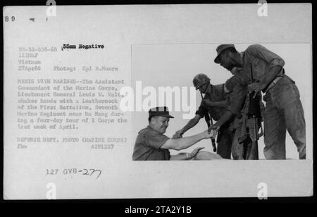 Commandant adjoint du corps des Marines, le lieutenant-général Louis W. Walt, serre la main d'un Marine du premier bataillon du septième régiment des Marines près de Da Nang lors d'une visite de quatre jours du Ier corps en avril 1968. Cette photographie capture une interaction entre des militaires de haut rang et des troupes pendant la guerre du Vietnam. Banque D'Images