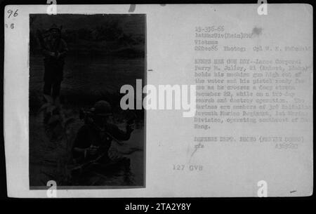 Le Caporal Perry M. Jolley de Rupert, Idaho, garde ses armes au sec alors qu'il traverse un cours d'eau profond lors d'une opération de recherche et de destruction le 22 décembre 1966. La photographie a été prise par le caporal W. E. McDonald. Jolley est membre du 3e bataillon du septième régiment de Marines, 1e division de Marines, opérant au sud-ouest de Ba Hang au Vietnam. Banque D'Images