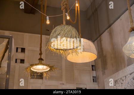 Décoration lanterne suspendue en bambou. lustres en rotin différentes formes sur fond de mur en bois. Abat-jour en paille dans le salon confortable. ECO Banque D'Images