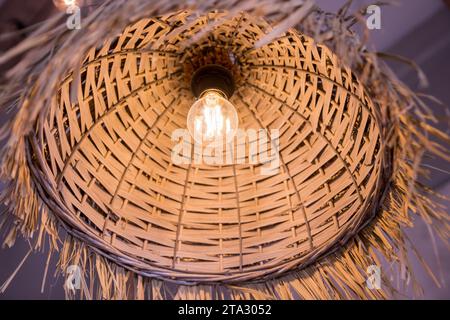 Décoration lanterne suspendue en bambou. lustres en rotin différentes formes sur fond de mur en bois. Abat-jour en paille dans le salon confortable. ECO Banque D'Images