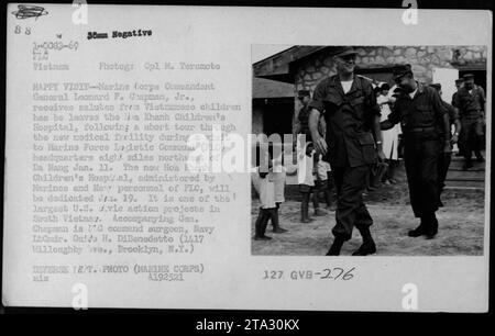 Le commandant du corps des Marines, le général Leonard F. Chapman, Jr., rend hommage aux enfants vietnamiens alors qu'il quitte l'hôpital pour enfants lba Khanh lors d'une visite au quartier général du Commandement logistique des Forces Marines (FLC). L'hôpital, administré par les Marines et le personnel de la Marine, sera bientôt dédié. Le général Chapman est accompagné du lieutenant Gmdt de la Marine. Guido H. DiBenedetto. Banque D'Images