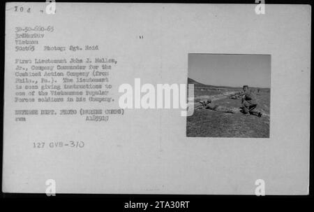 Premier lieutenant John J. Mullen, 3., commandant de compagnie de la Compagnie d'action combinée (originaire de Philadelphie, Pennsylvanie) donnant des instructions à un membre des soldats des Forces populaires vietnamiennes de sa compagnie. La photographie légende des détails de l'ARVN (Armée de la République du Vietnam) - 5 octobre 1965. DEPT. DÉFENSE PHOTO (ARTE CORPS) A185919 PUM 127 GVB-3/0 Banque D'Images