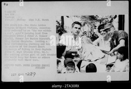 Aumônier (crdr.) Feter J. Bakker et le capitaine Jamon E. Keys distribuent des vêtements et des livres aux orphelins de l'orphelinat du Sacré-cœur de Delang dans le cadre du Programme d'action civique au Sud-Vietnam. Une petite fille décide de garder sa robe pendant que d'autres attendent patiemment leur tour. Banque D'Images